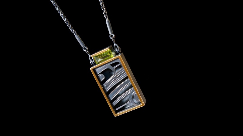 “Ksiyeen” Skeena River Pendant Morgan Green Tsimshian oxidized silver, 14 karat gold, Peridot 2”H X 1 ½”W X ¼”D, 18" chain